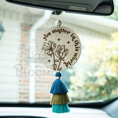 a tasselled keychain hanging from the front window of a car that says, you matter when driving