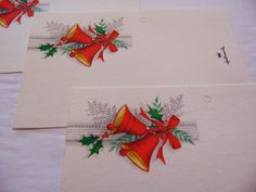 three christmas cards with bells and holly on them