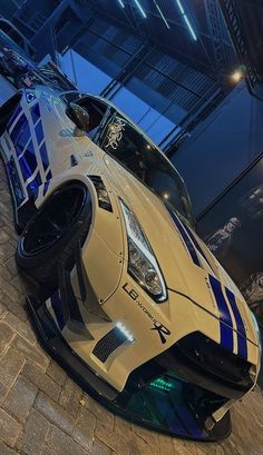 a white and blue sports car on display in a building