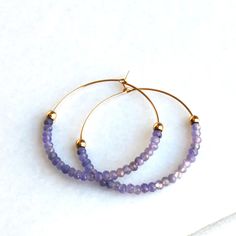 Tanzanite Gold Hoop Earrings D E T A I L S These gorgeous hoop earrings are created with Genuine Natural Tanzanite 3mm beads and 14kt gold filled accents   Beaded by hand  14kt gold filled 35mm hoops  ∙ EXTRA LOVE ∙ Crafted and curated just for you in the desert of our Arizona studio. All of our jewelry comes gift packaged!  We are happy to leave a note if this is a special gift, just let us know in the message box at checkout.  PRODUCTION ∙ TIMES All items are made to order. Please check the top of our policies page for the most current production time before shipping. If you need it sooner, select a faster shipping at checkout.  ∙ What is gold filled? ∙ Gold filled jewelry is beautiful long lasting material, it is very durable and will not chip or turn colors. With proper care it can las Faceted Hoop Earrings As Gift, Purple Hoop Earrings As Gift, Faceted Hoop Jewelry For Gifts, Jewelry Hoop Earrings, Earrings Gold Hoop, Tanzanite Jewelry, Tanzanite Earrings, Gift Best Friend, Hoop Earrings Gold