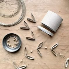 some metal objects are laying out on a wooden table with beads and wire around them