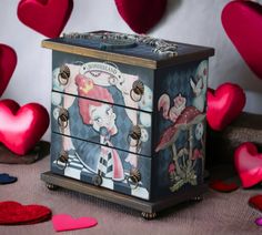 a decorative box sitting on top of a table with hearts flying in the air behind it