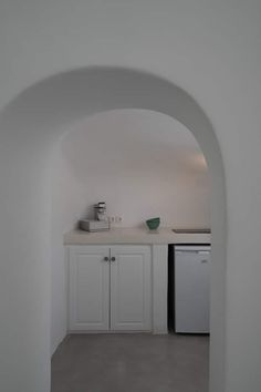 an archway leading into a kitchen with white cabinets