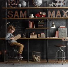 a young boy is sitting on a chair in front of a desk with books and toys