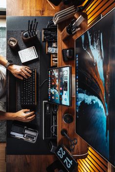 a man sitting at a desk working on a computer with his hands on the keyboard