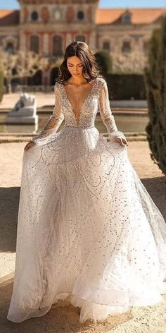 a woman in a white wedding dress standing on the ground with her back to the camera