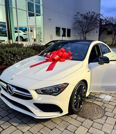 a white car with a red bow on it