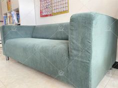 a blue couch sitting on top of a tiled floor