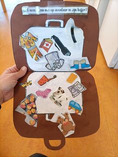 someone is holding up a suitcase with stickers on the front and inside, which has been cut out to look like an animal