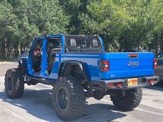 a blue jeep with its doors open in a parking lot