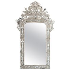 an ornate mirror is shown against a white background with flowers and leaves on the frame