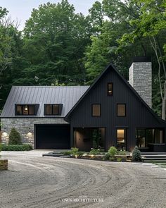 a large black house surrounded by trees and bushes