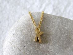 A tiny matt gold plated initial letter 'K' pendant dangles from a fine gold plated chain necklace. Simple and modern. Initial 'K' pendant is matt gold plated, double sided, tarnish resistant, size - 5 x 7mm Fine link chain necklace is gold plated, various sizes available, please select the length you require above. Also available in silver:- https://www.etsy.com/listing/150353855/tiny-initial-alphabet-letter-k-necklace?ref=shop_home_active Other alphabet letters available - A-Z in gold and silve Letter K Necklace, K Necklace, Letter K, Necklace Simple, Link Chain Necklace, Gold Initial, Alphabet Letters, Personalized Initials, Initial Letter