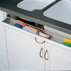 two sinks with toothbrushes, soap and other items in the sink drawer area