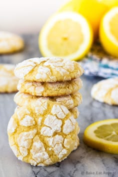 three lemon cookies stacked on top of each other next to sliced lemons and two lemon halves