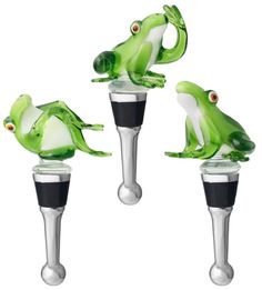 three green glass frog bottle stoppers with black caps and eyes on each one side