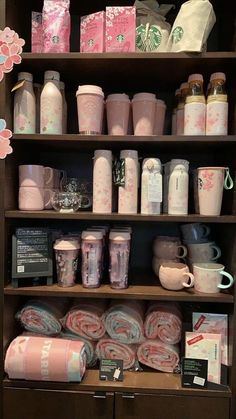 the shelves are filled with different types of cups and items in pink, white and blue