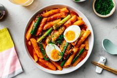 a bowl filled with carrots, asparagus and hard boiled egg on top