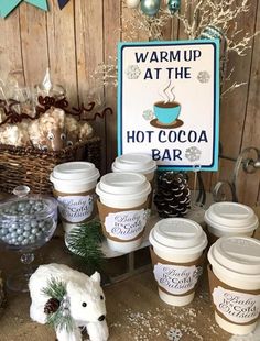 hot cocoa cups are on display in front of a sign that says warm up at the hot cocoa bar