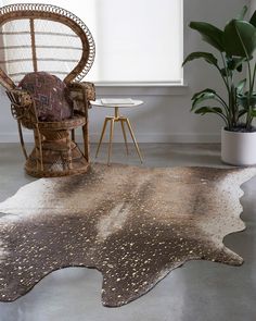 a living room area with a chair, rug and potted plant