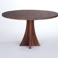 a round wooden table with an unusual design on the top and two small circular legs