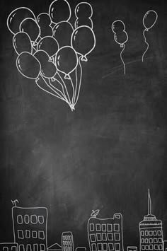 chalk drawing of balloons and cityscape on blackboard