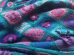 there is a crocheted blanket that has been made with many different colors and shapes