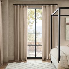 a bed sitting next to a window in a bedroom