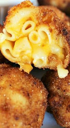 macaroni and cheese is cut in half on a plate with other food items