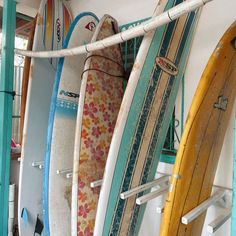 several surfboards are lined up against the wall