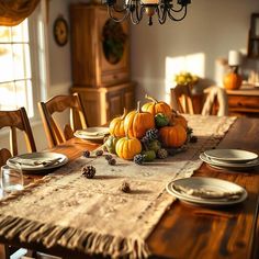 a wooden table topped with lots of pumpkins and pineconi on top of it