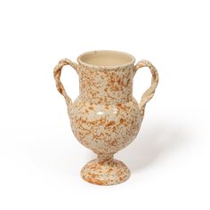 a white and brown vase sitting on top of a table