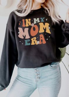 Celebrate motherhood with our In My Mom Era sweatshirt. Perfect for Mother's Day, baby showers, or just to show appreciation to the amazing mamas in your life.  Available on other variations for tshirts, sweatshirts and hoodies: * https://www.etsy.com/shop/TheNims?search_query=in+my+mom+era * https://www.etsy.com/shop/TheNims?search_query=in+my+mama+era Browse through my other awesome items here: http://thenims.etsy.com/ ABOUT THE PRODUCT: Unisex Heavy Blend™ Crewneck Sweatshirt | GILDAN 18000 ( Graphic Print Sweatshirt For Birthday And Mother's Day, Mother's Day Birthday Graphic Print Sweatshirt, Mother's Day Graphic Print Sweatshirt, Club Concert Outfit, 1st Time Mom, Fall Baby Announcement, College Mom, Cool Moms Club, In My Mom Era