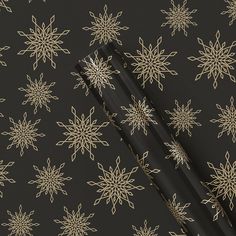 black and gold snowflakes on a dark background with white lines in the middle