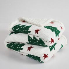 three white and green christmas towels stacked on top of each other