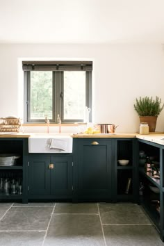 a kitchen with dark green cabinets and white counter tops is seen in this image from the front