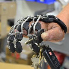 a hand holding several keys with chains on them