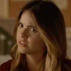 a close up of a person wearing a red shirt and looking off to the side