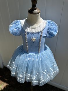 Transform your little one into a winter wonderland with our Frosty Snowflake Princess Dress. This enchanting light blue dress features a beautifully detailed bodice adorned with sparkling sequins, pearls, and delicate lace trim. The puffed sleeves add a touch of whimsy, while the tulle skirt is decorated with intricate snowflake patterns and shimmering accents, creating a magical, frosty effect. Ideal for themed parties, dress-up play, or special occasions, this dress captures the essence of win Intricate Snowflake, Snowflake Patterns, Girls Costumes, Snow Princess, Light Blue Dress, Winter Fairy, Princess Inspired, Light Blue Dresses, Snowflake Pattern