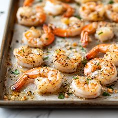 a pan filled with cooked shrimp and garnished with seasoning sprinkles