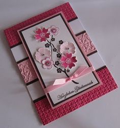 a pink and white card with flowers on it