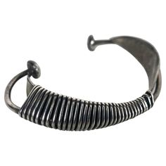 This modernist sculptural piece is one of Wiener's first creations as a jeweler-artist, in New York City, circa 1954.This cuff bracelet is composed of two simple aerodynamic pieces with sinuous curved shapes wrapped by an infinite wire, which in turn recreates a sculpture with constructivism patterns,, Stunning iconic piece of modernist jewelry.. Has a weight of 34.6 grams and fit a wrist up to 7 inches. Modern Hand Cast Adjustable Bracelets, Modern Adjustable Hand Cast Bracelets, Contemporary Metal Cuff Bracelet, Unique Oxidized Metal Cuff Bracelet, Unique Metal Cuff Bracelet With Oxidized Finish, Modern Hand Forged Metal Bracelet, Modernist Sterling Silver Bangle, Modernist Metal Bangle Jewelry, Sterling Silver Modernist Bangle