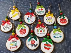 decorated cookies with teacher's day designs on them are laid out on a cutting board