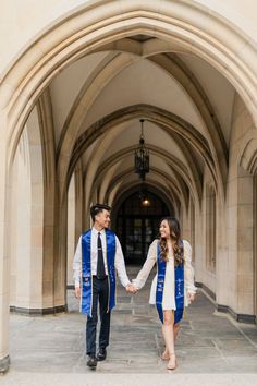 a man and woman holding hands in front of an archway