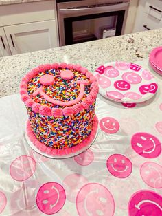 a birthday cake sitting on top of a table covered in pink frosting and sprinkles