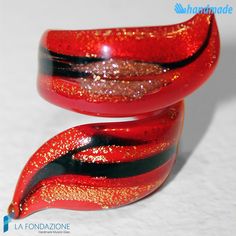 "Ribbon/Spiral ring that wraps the finger completely, with bright red, black, and gold colors that recall those of volcanic lava. Handmade ribbon ring with certified Murano glass, minimal thickness gold leaf to enhance the splendid decoration created with brown aventurine.  A ring with captivating colors, with a complete range suitable for summer as well as winter. A jewel that certainly does not go unnoticed.  Each glass jewel is shipped in a rigid gift box, with the possibility of attaching your own greeting card. Each of our rings is engraved with the word \"Murano glass\" to make it authentic and unique. If this is not the ring for you, we have many others in our Etsy shop https://www.etsy.com/it/shop/LaFondazioneMurano?section_id=27677179 They are available in IT sizes 14 to 22 and US Red Spiral Jewelry For Gifts, Spiral Shaped Red Jewelry For Gifts, Red Spiral Jewelry As Gift, Venetian Art, Ribbon Ring, Gift Box Jewelry, Personalized Ribbon, Spiral Ring, Gold Colors