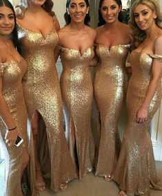 four women in gold dresses posing for the camera