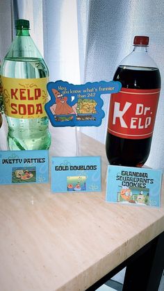 two bottles of soda sit next to each other on a table with cards and magnets