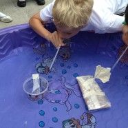 a young boy is playing with some sort of device on the table in front of him