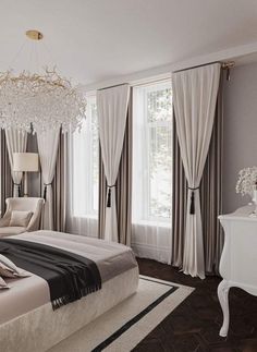 a bedroom with a bed, chandelier and two windows in the room that have drapes on them